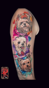 tatuagem na parte superior do braço do rosto de 3 cachorros no estilo aquarela