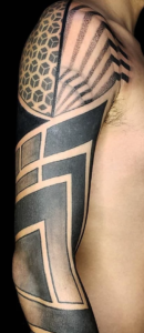 tatuagem fechando o braço com desenhos geométricos em preto